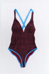 Malla enteriza con estampado animal print en tonos marrones y negros, con breteles finos cruzados en la espalda de color celeste.