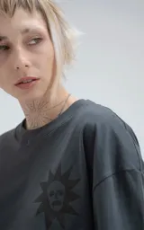 Remera negra de corte holgado con estampado de calaveras y cruz en el frente.