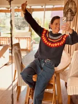 Sweater tejido a mano en mohair, color gris oscuro con cuello redondo y diseño geométrico en el pecho en tonos blanco, naranja y rojo.