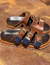 Sandalias de cuero marrón con hebillas metálicas y plantilla de corcho.