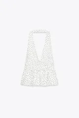 Top negro de cuello halter y escote pico con volantes en el bajo.