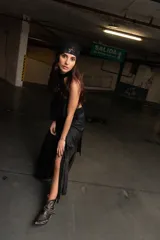Falda larga negra con corte irregular, confeccionada con una tela opaca en la parte superior y una tela brillante con textura en la parte inferior.