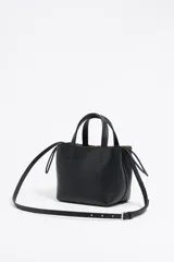 Bolso tote pequeño color visón de piel granulada con doble asa corta y correa bandolera ajustable y extraíble. Incluye bolsa interior ajustable con cordones. Logotipo de la marca grabado en el frente.