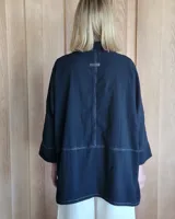 Camisa celeste de corte amplio, con cuello clásico y mangas largas.