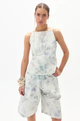 Top de denim con estampado floral en tonos celeste, lila y verde. Diseño ajustado con breteles finos.