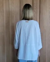 Camisa celeste de corte amplio, con cuello clásico y mangas largas.