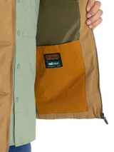 Chaleco inflable color marrón claro con cuello alto y cierre frontal con cremallera. Tiene dos bolsillos laterales y un bolsillo en el pecho con cierre.