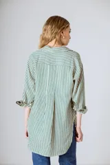 Camisa holgada de manga larga con rayas verticales verdes y blancas. El ruedo es más largo en la parte trasera.