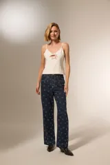 Pantalón de jean azul oscuro con estampado de corazones blancos, corte ancho y tiro alto.