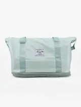 Bolso de viaje plegable color verde agua, con base gris y cierre superior.