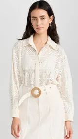 Camisa color blanco hueso con cuello clásico, tapeta con botones en la parte delantera y corte recto ligeramente oversize. Diseño con acabado de encaje.