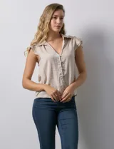 Camisa color beige de satén, con cuello con solapa y escote en V. Tiene una apertura central con botones y sisas con volados.