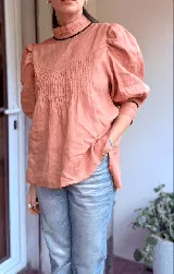 Blusa color crudo de lino con cartera frontal con puntilla y mangas abullonadas.