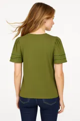 Remera verde oliva de algodón, con cuello redondo, mangas cortas abullonadas con detalle de calado y corte holgado.