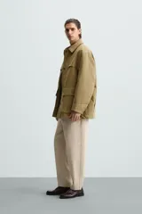 Pantalón verde militar de corte carrot fit, confeccionado en tejido de algodón. Cuenta con cintura elástica ajustable con cordón, bolsillos frontales y un bolsillo trasero de plastrón.