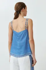 Top azul con estampado geométrico, breteles finos dobles y escote en V.