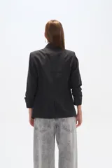 Blazer color crema de poliéster, de corte entallado, con cuello solapa y mangas largas.