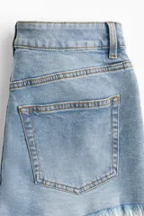 Short de jean celeste con tiro alto, cinco bolsillos y ruedo desflecado.