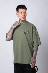 Remera color ladrillo de corte oversize, con cuello redondo y mangas cortas. Estampado pequeño en el pecho con un diseño circular en blanco y negro.