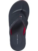 Ojotas Tommy Hilfiger azul marino con suela roja y tiras con logo de la marca.