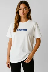 Remera blanca de algodón con cuello redondo, manga corta y estampado frontal con la frase "STAND FREE" en color azul.