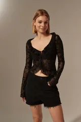 Blusa negra ajustada con diseño de flores y escote en V, de manga larga.