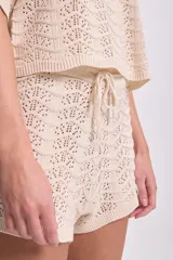 Short tejido al crochet color crudo, con cintura elastizada y cordón ajustable.