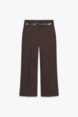 Pantalón marrón de tiro alto con cinturón negro, bolsillos delanteros y cierre frontal con cremallera y gancho metálico.