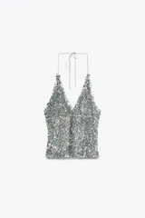 Top plateado con lentejuelas, cuello halter ajustable con lazada y forro interior de tul.