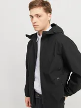 Campera negra liviana con capucha ajustable, cierre frontal con cremallera y bolsillos delanteros con cierre. Puños de canalé.