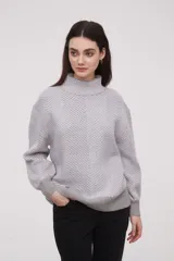 Sweater de punto con diseño de chevron en tonos gris y blanco, de manga larga y cuello alto.