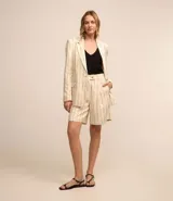 Bermuda de sastrería color beige con rayas verticales finas en azul marino. Tiene trabillas, pliegues y cierre con botones en la cintura.
