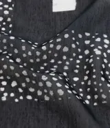 Pareo rectangular de chiffon con estampado de lunares en blanco y negro, con terminaciones de borlas.