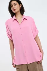 Camisa color rosado con cuello clásico, abotonada al frente y mangas 3/4 con trabillas.