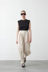 Top sin mangas de color negro con textura floral en relieve, cuello redondo y diseño estructurado.