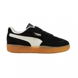 Championes Puma Palermo de gamuza negra con franja lateral blanca y suela de goma color caramelo.