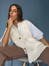 Chaleco tejido a mano con escote en V, bordado con botones, confeccionado en algodón con detalles de lurex. Terminaciones en crochet y bordados hechos a mano con lana merino.