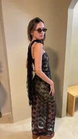 Vestido largo negro con estampado dorado, de breteles finos y corte ajustado.