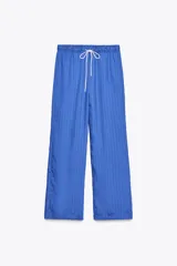 Pantalón de lyocell color azul con rayas verticales, tiro medio, cintura elástica ajustable con cordones y pierna ancha.