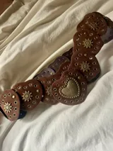 Cinturón marrón de cuero sintético con corazones y detalles dorados.