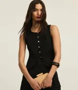 Chaleco negro de sastrería con cuello redondo, cierre frontal con botones metálicos y lazo cruzado en la espalda.