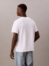 Remera blanca de algodón con logo "Calvin Klein Jeans" estampado en azul en el pecho.