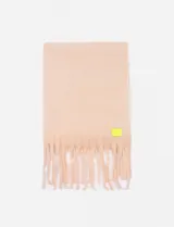 Bufanda rectangular color beige con flecos en los extremos y etiqueta amarilla fluorescente.