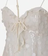 Blusa corta color crema, con lentejuelas y escote corazón. Tiene breteles finos ajustables, lazo en el busto y volados de chiffon.