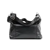 Bolso tote negro de cuero con correa ancha de tela con letras blancas.