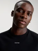 Remera negra de algodón con cuello redondo, mangas cortas y logo Calvin Klein nano en el pecho.