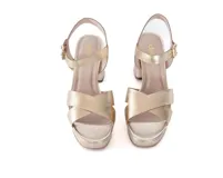 Sandalias de cuero metalizado color dorado, con plataforma y taco cuadrado. Presentan tiras cruzadas sobre el empeine y pulsera con hebilla al tobillo.