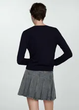 Sweater rojo de punto fino con cuello en V y mangas largas.