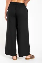 Pantalón de lino color ocre, de corte recto y tiro medio, con lazo de ajuste en la cintura.