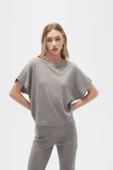 Remera gris de poliéster y lurex, manga corta, corte holgado y cuello a la base.